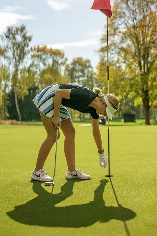 About Us 1 Golfer picking the ball out of the hole